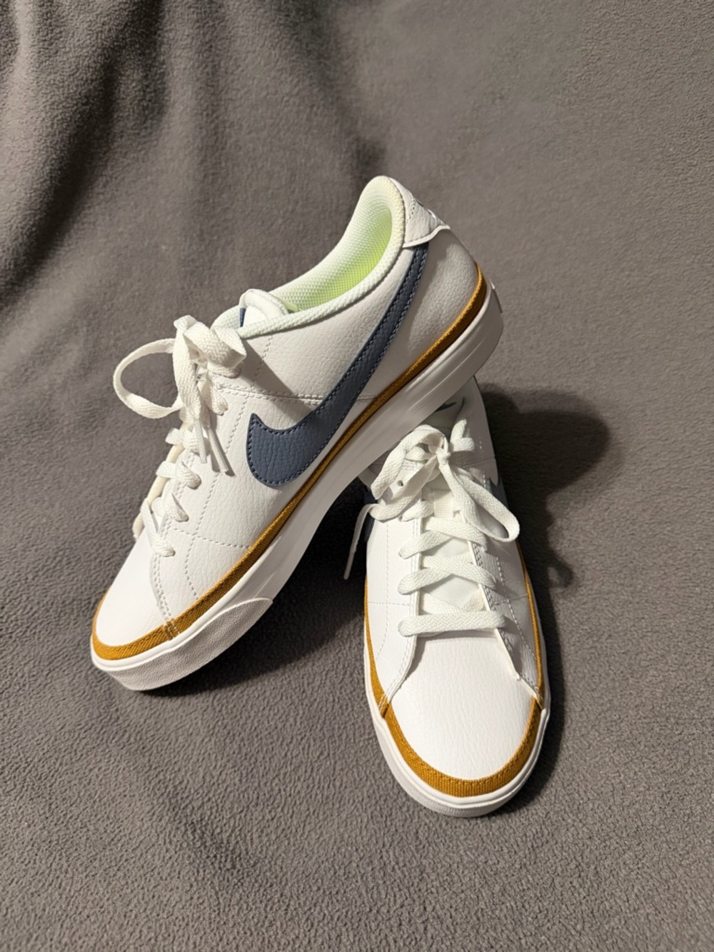 Nike Women's White Leather Sneakers with Blue Swoosh and Gold Accent
